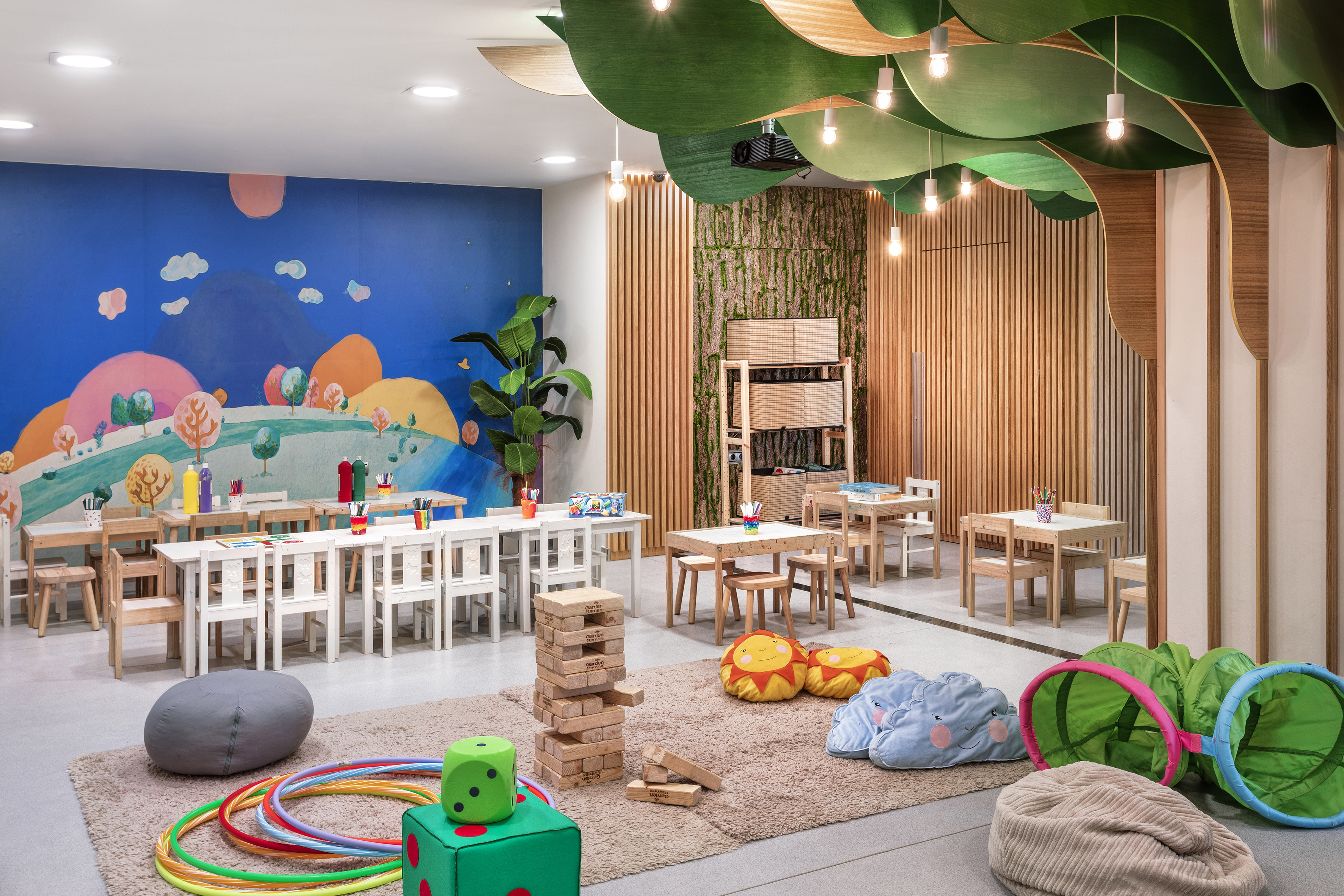 Vibrant kids' playroom with art stations, colorful mural, and interactive toys.