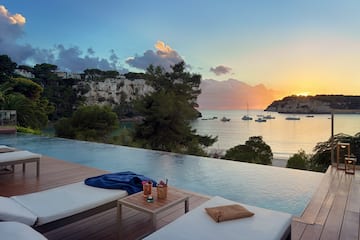 a pool with a view of the ocean and boats in the background