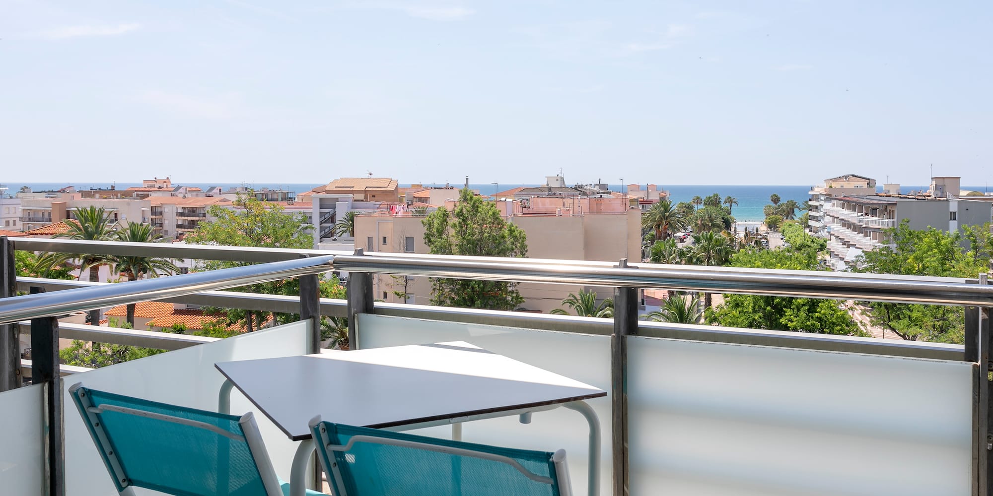 a table and chairs on a balcony overlooking a city