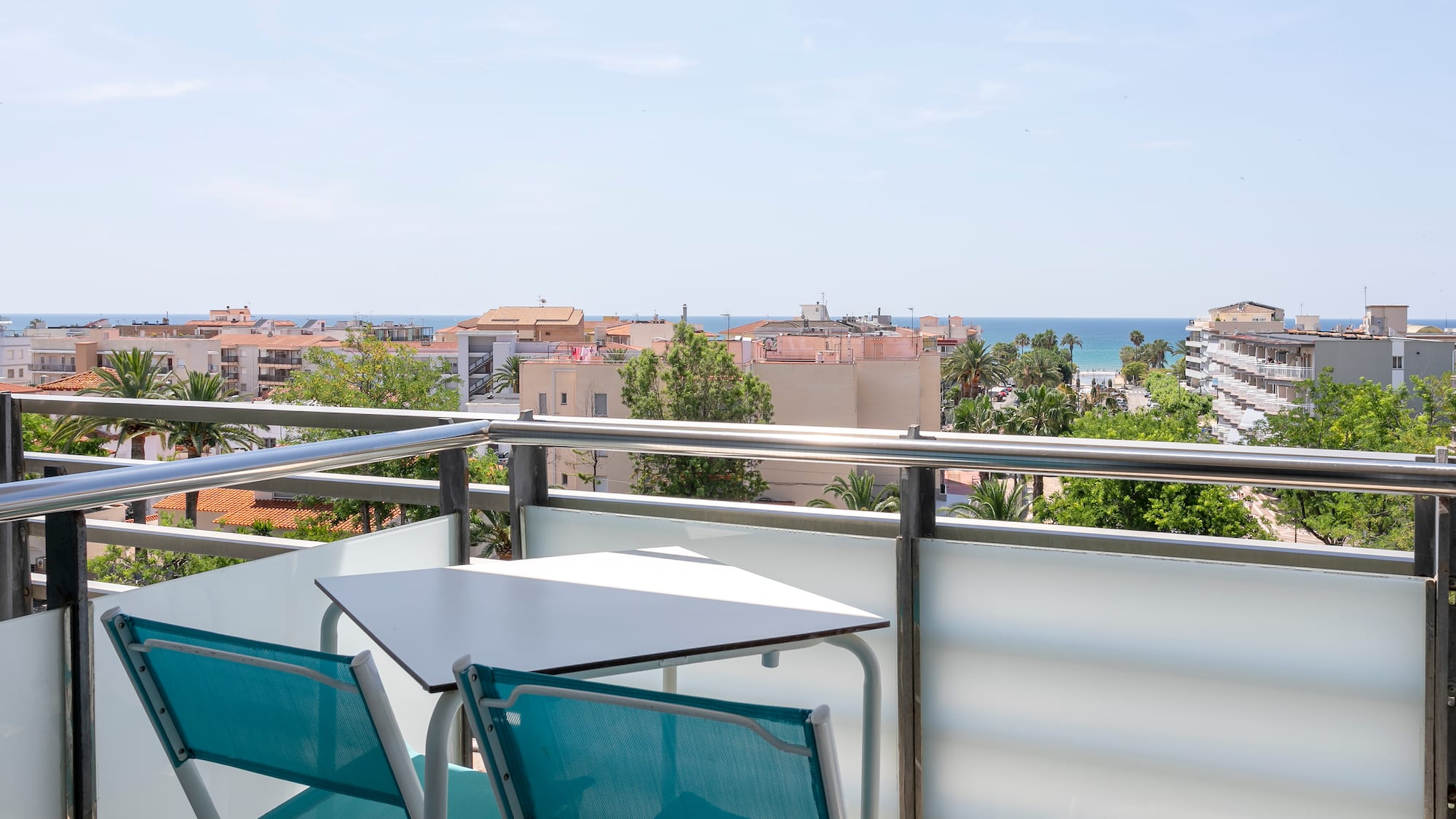a table and chairs on a balcony overlooking a city