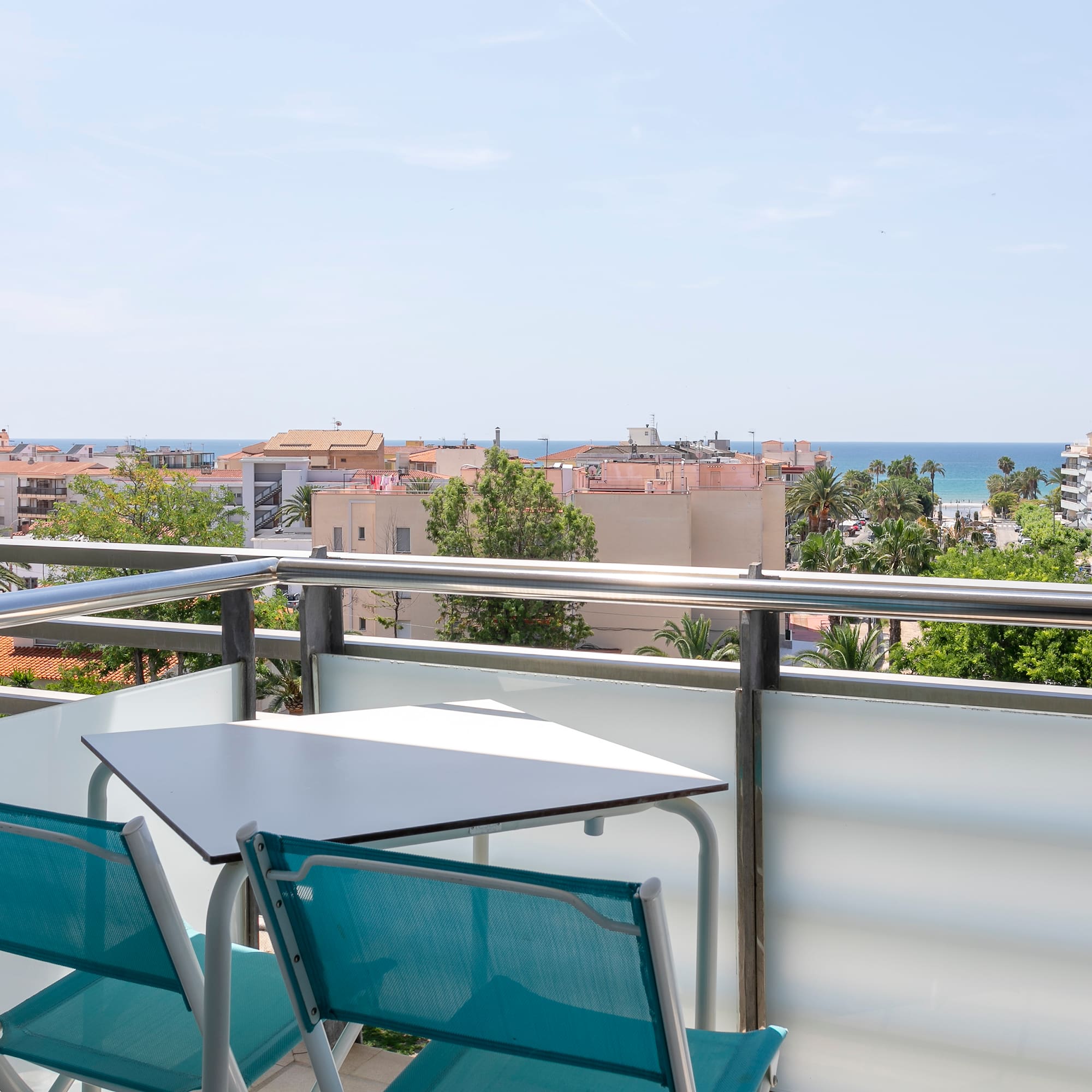 a table and chairs on a balcony overlooking a city