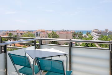 a table and chairs on a balcony overlooking a city