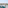Balcony with turquoise chairs, table, and sea view of a sunny coastal town.