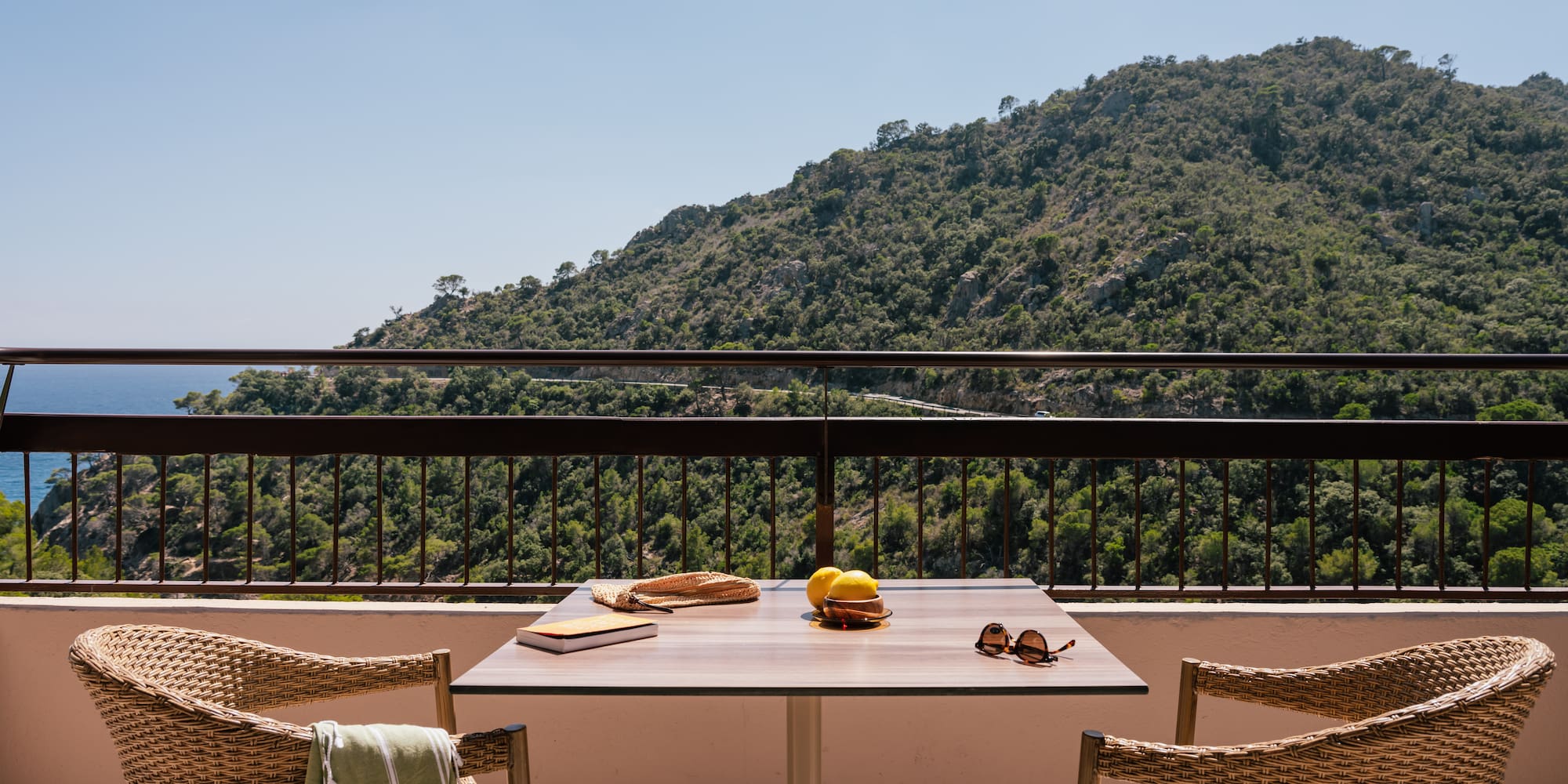 a table and chairs on a balcony overlooking a mountain