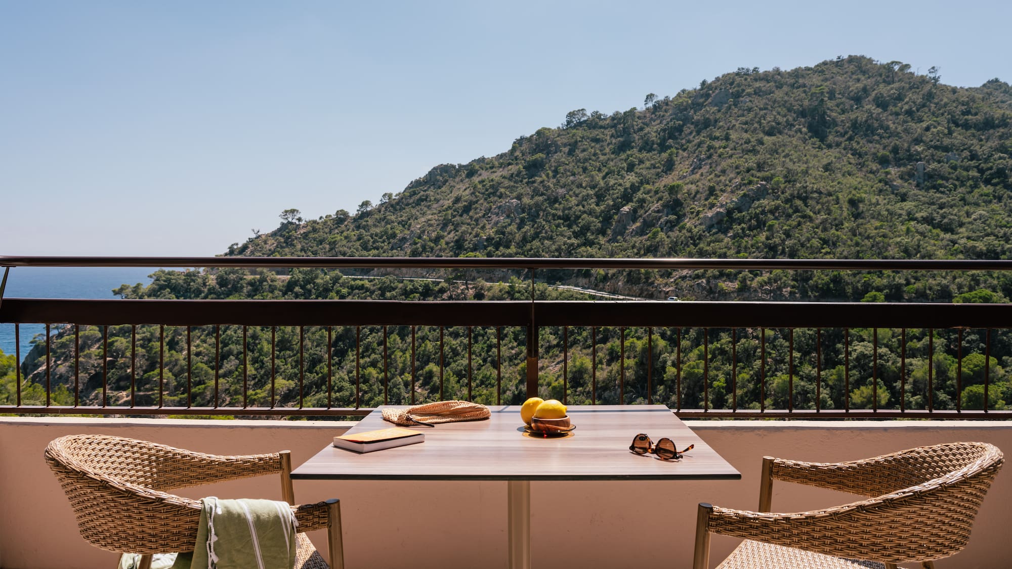 a table and chairs on a balcony overlooking a mountain
