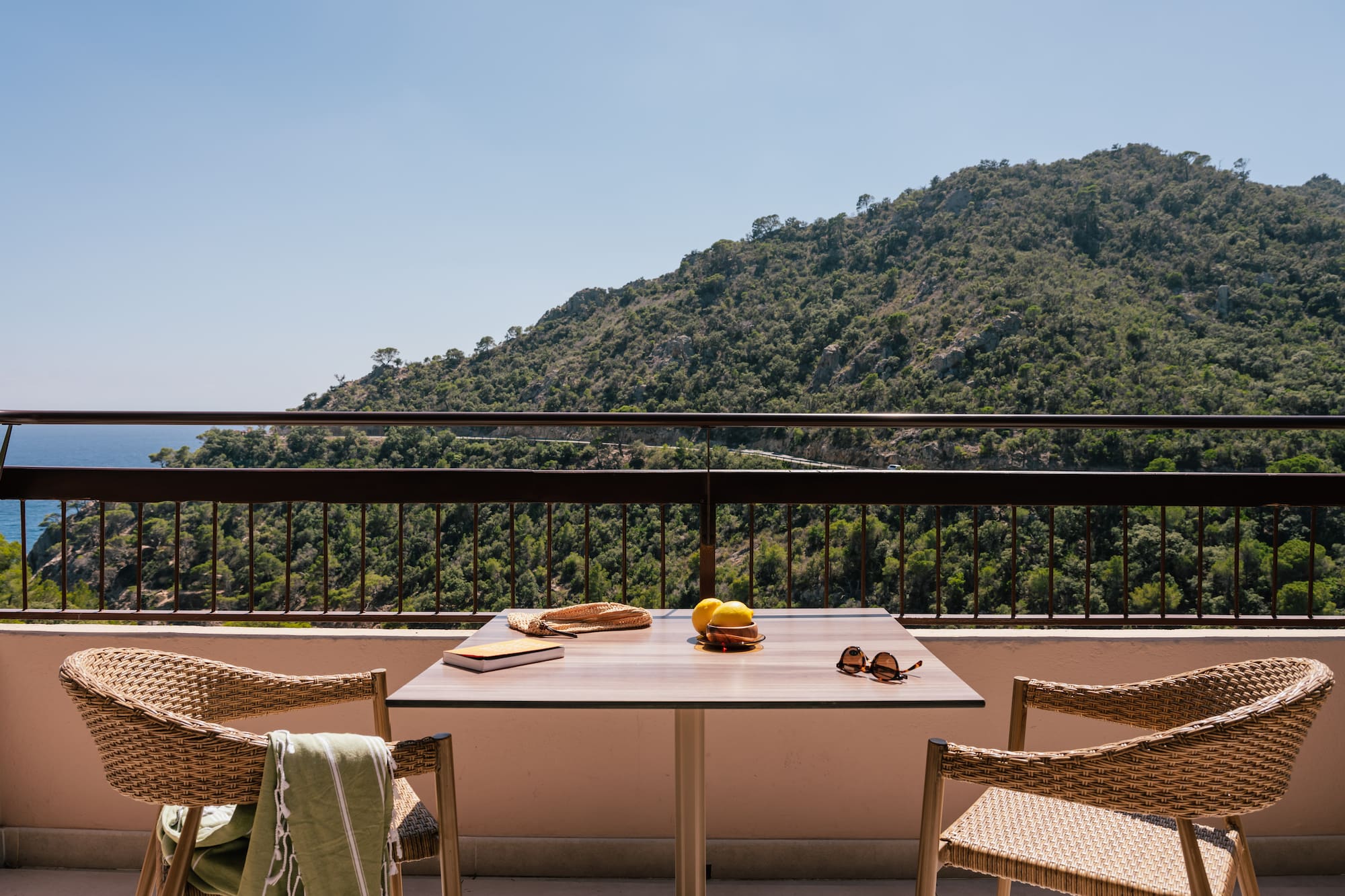 a table and chairs on a balcony overlooking a mountain