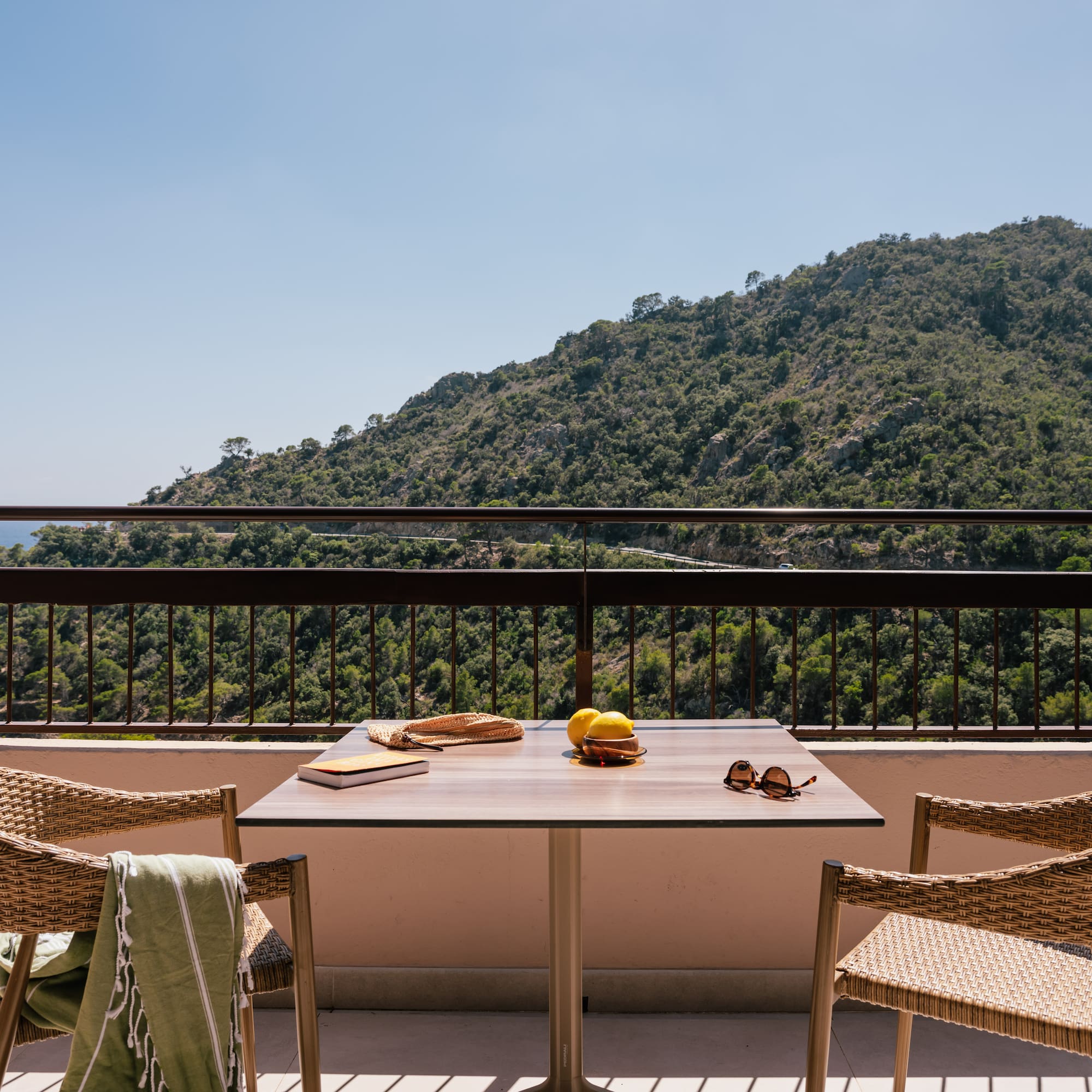 a table and chairs on a balcony overlooking a mountain