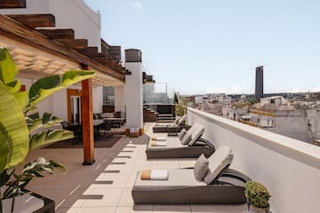 a patio with chairs and a roof top