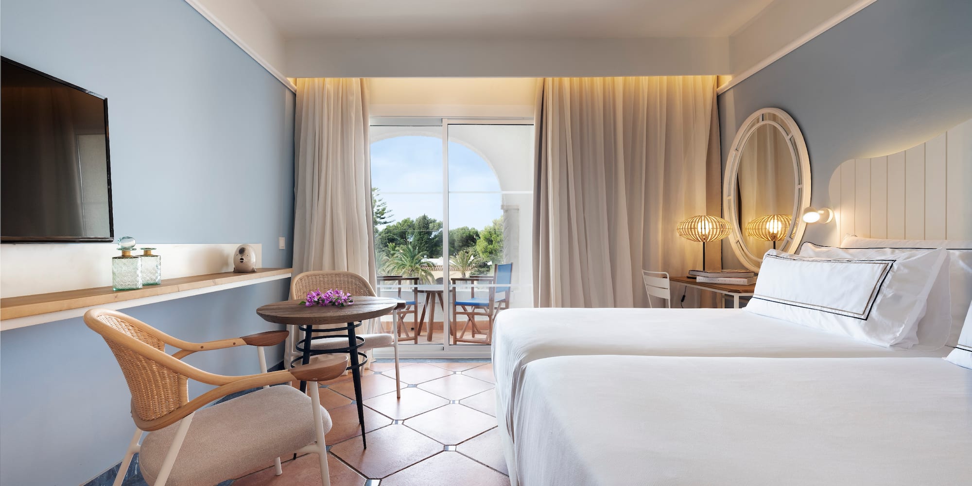 a room with two beds and a table and chairs