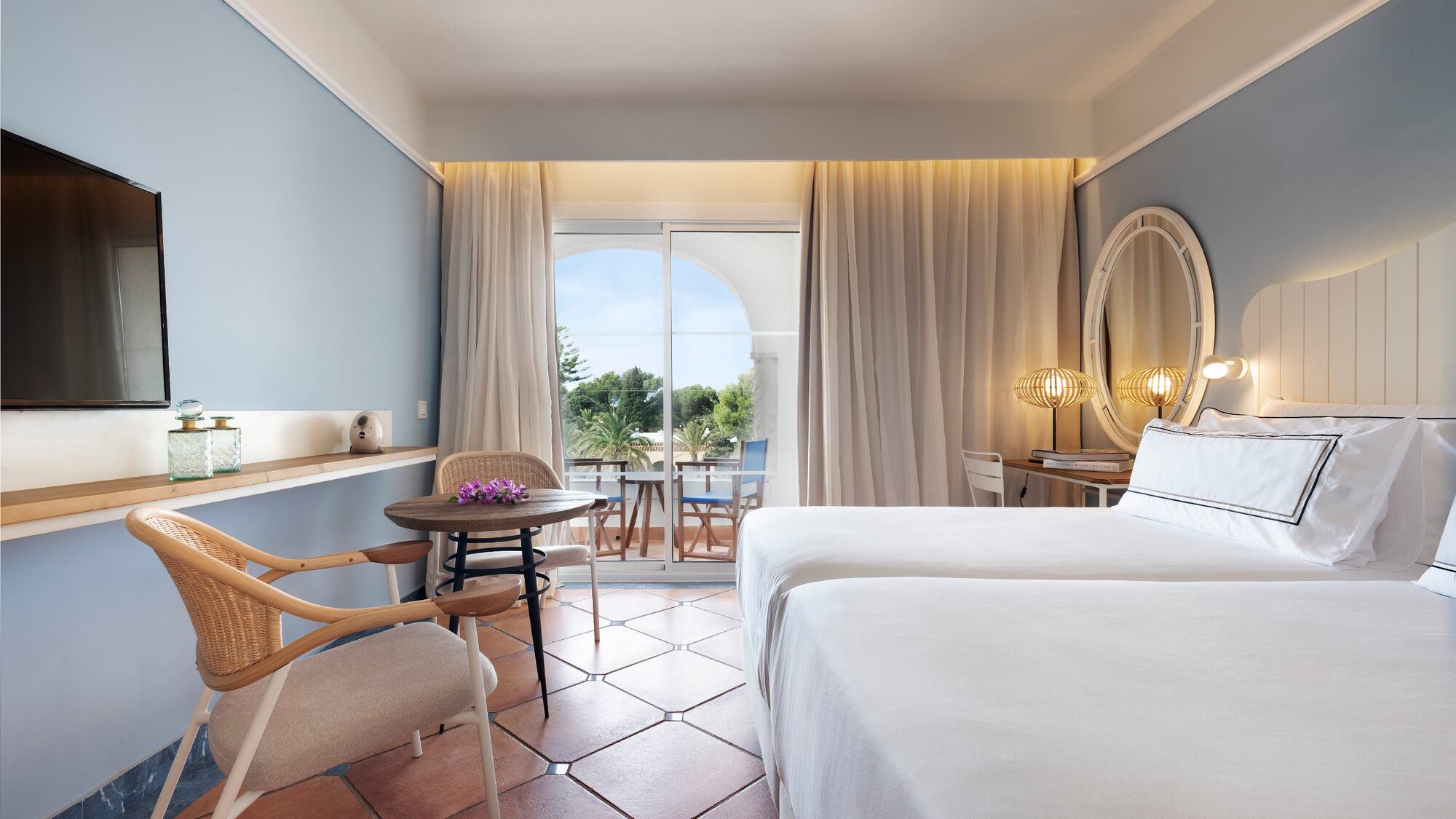 a room with two beds and a table and chairs