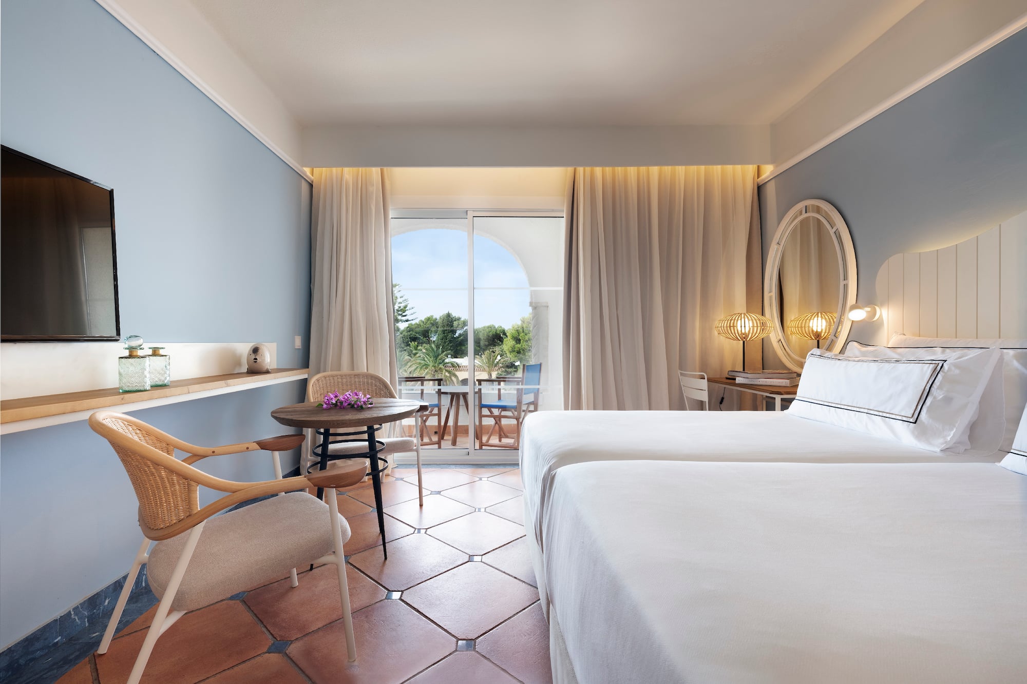 a room with two beds and a table and chairs