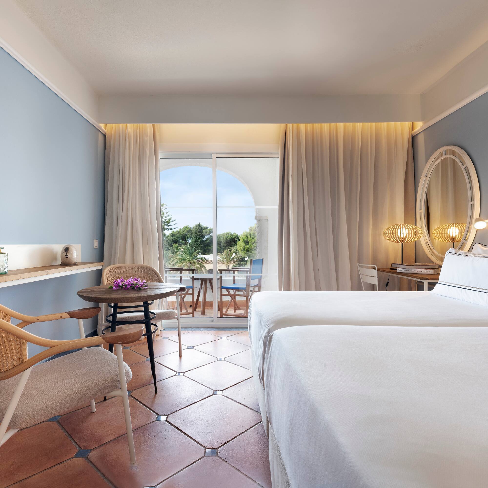 a room with two beds and a table and chairs