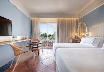 a room with two beds and a table and chairs