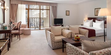 a room with a bed and chairs