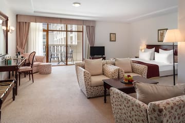 a room with a bed and chairs