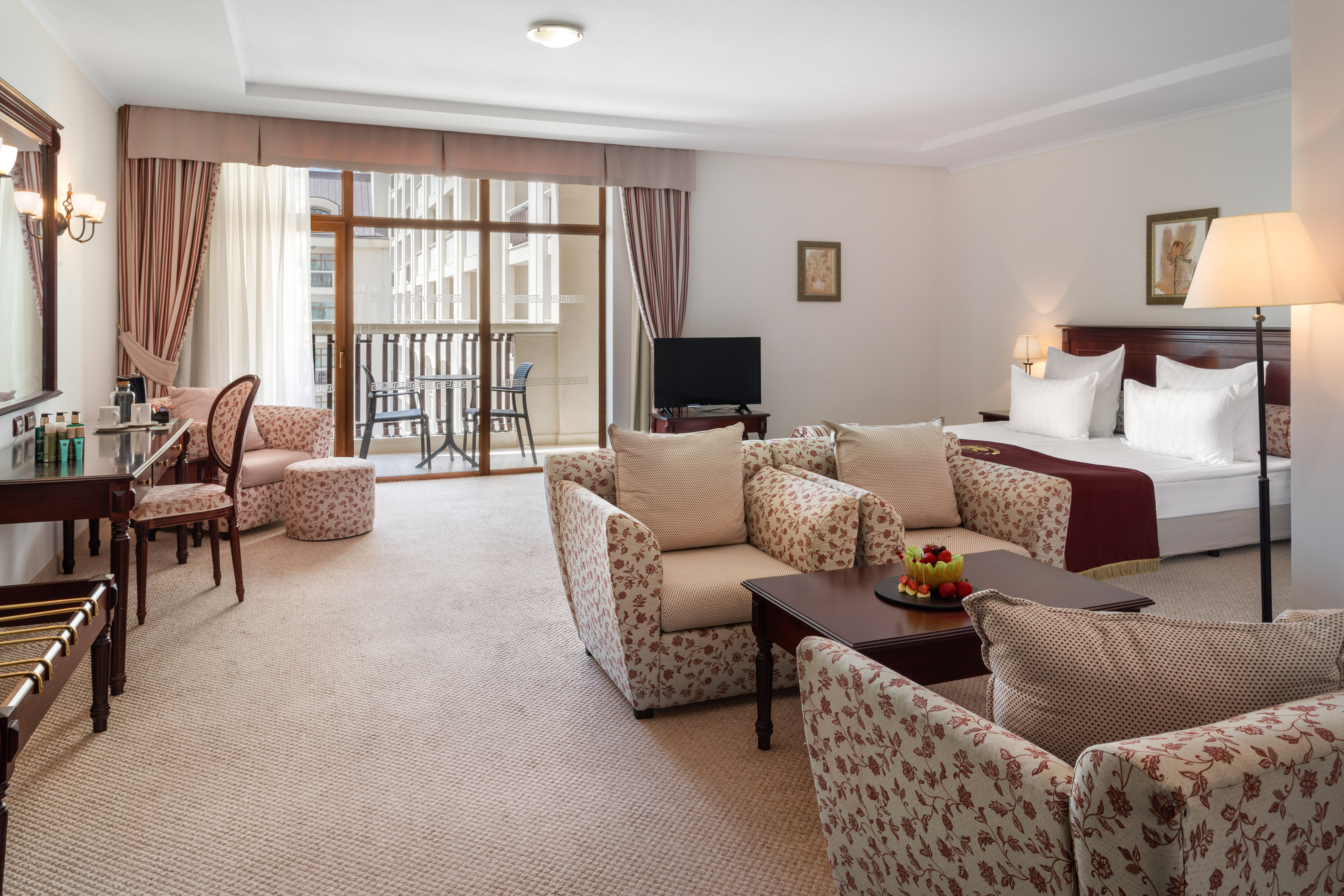 a room with a bed and chairs