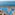 Tropical resort water park overlooking the sea with pools and palm trees.