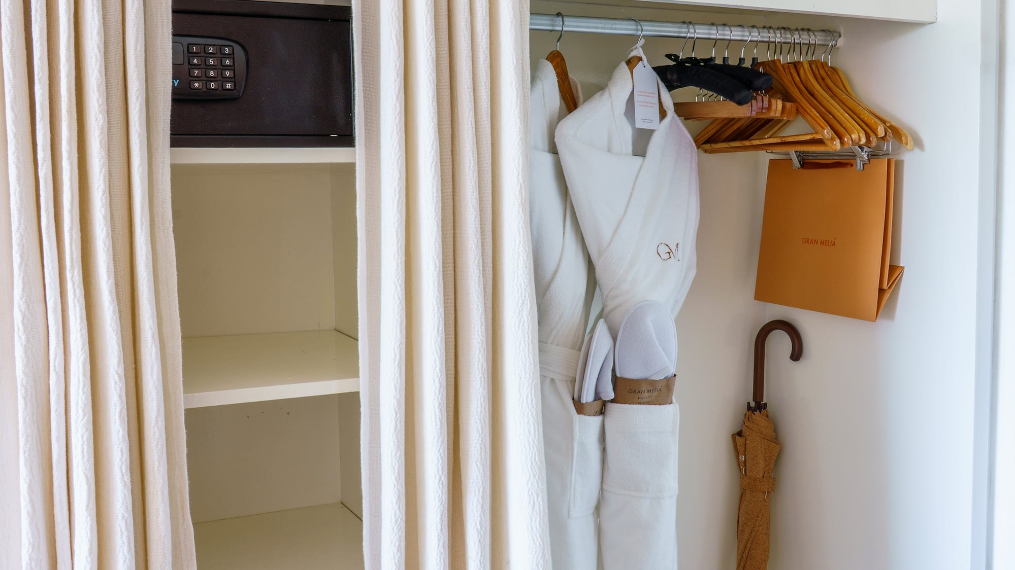 a closet with white towels and umbrellas