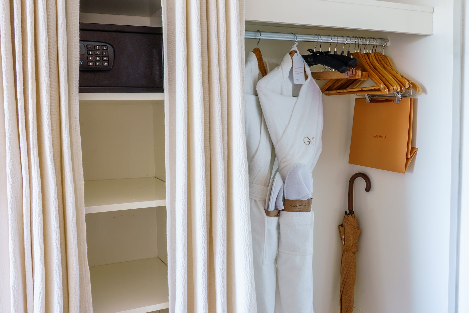 a closet with white towels and umbrellas