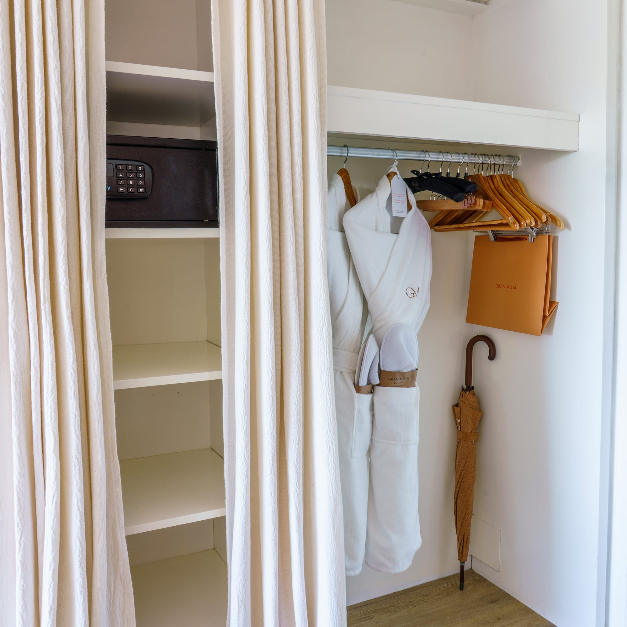 a closet with white towels and umbrellas