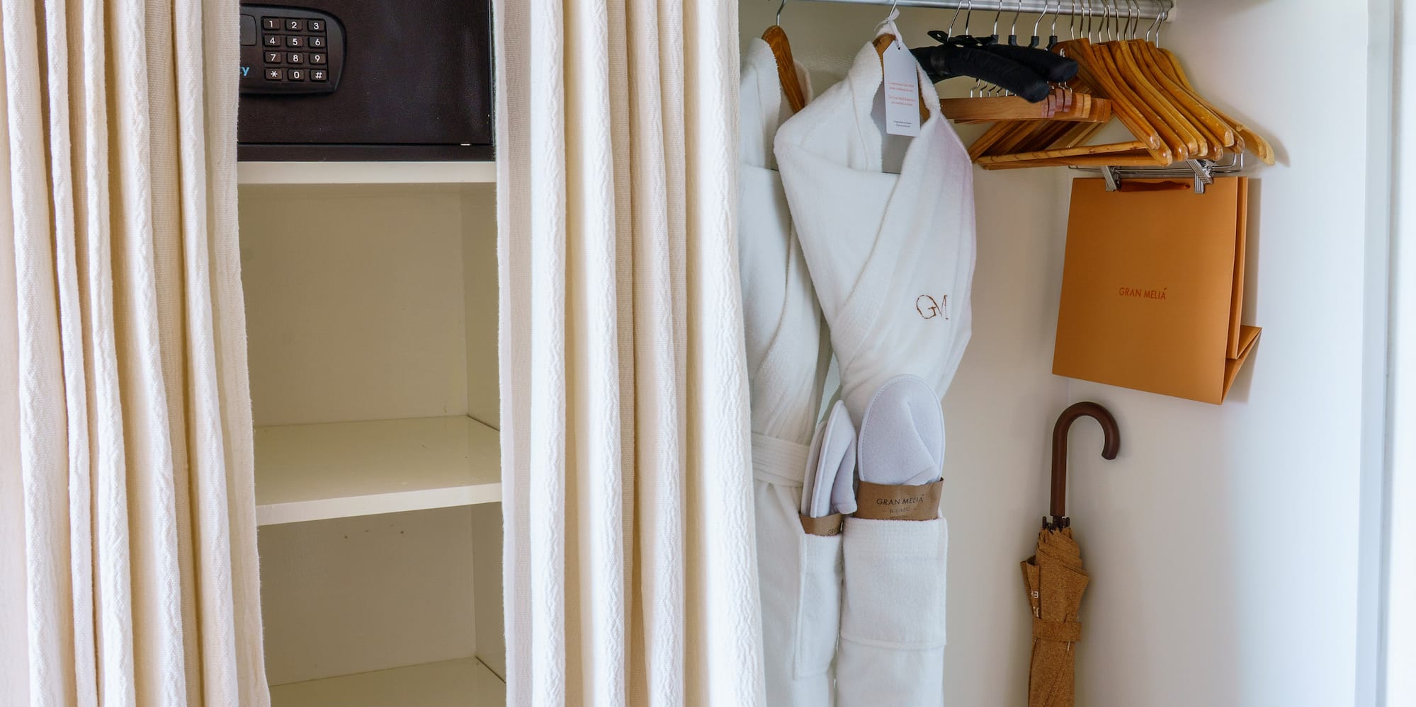 a closet with white towels and umbrellas