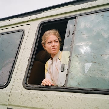 a woman looking out of a window of a van
