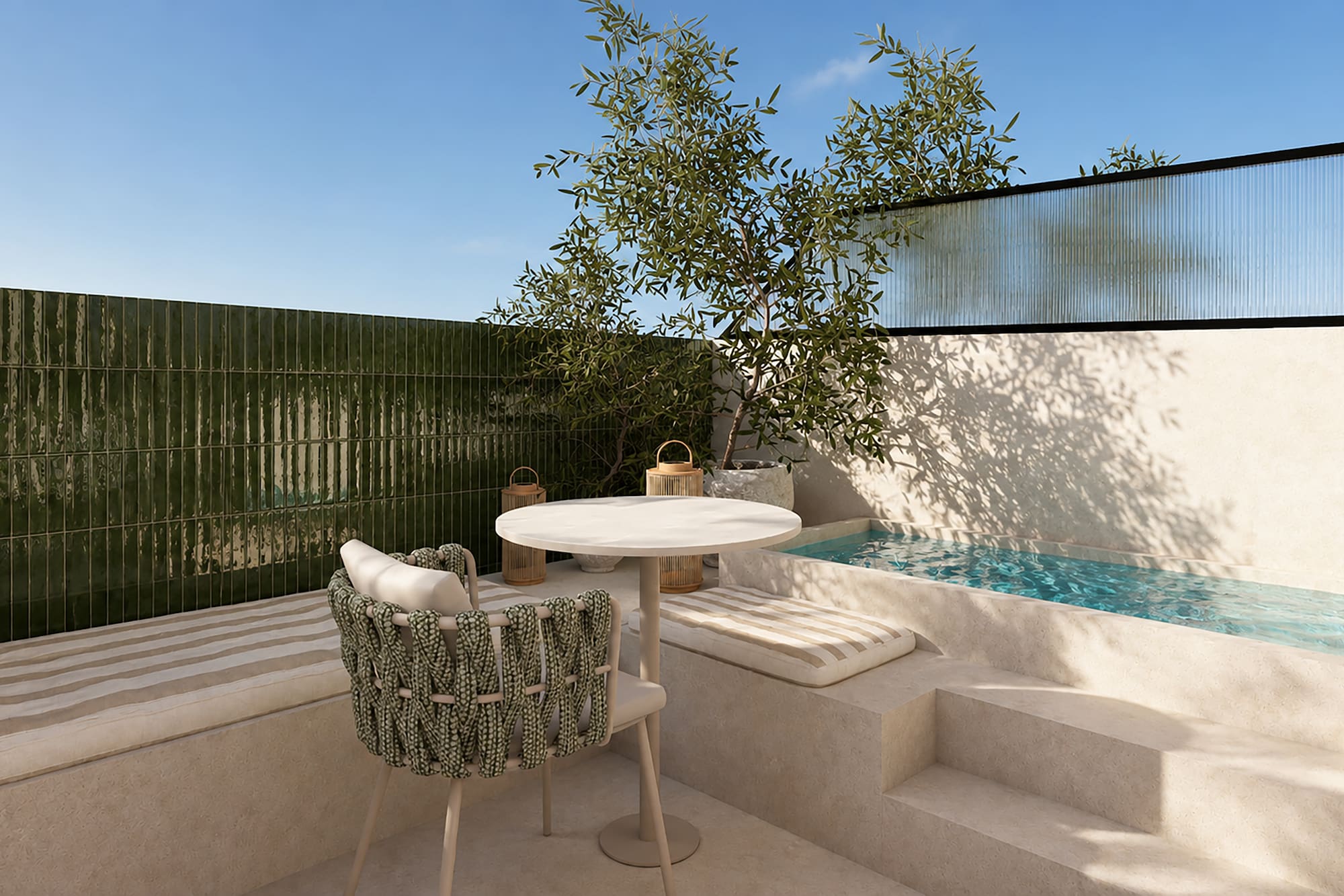 Patio mediterráneo con piscina, azulejos verdes, mesa redonda y olivo.