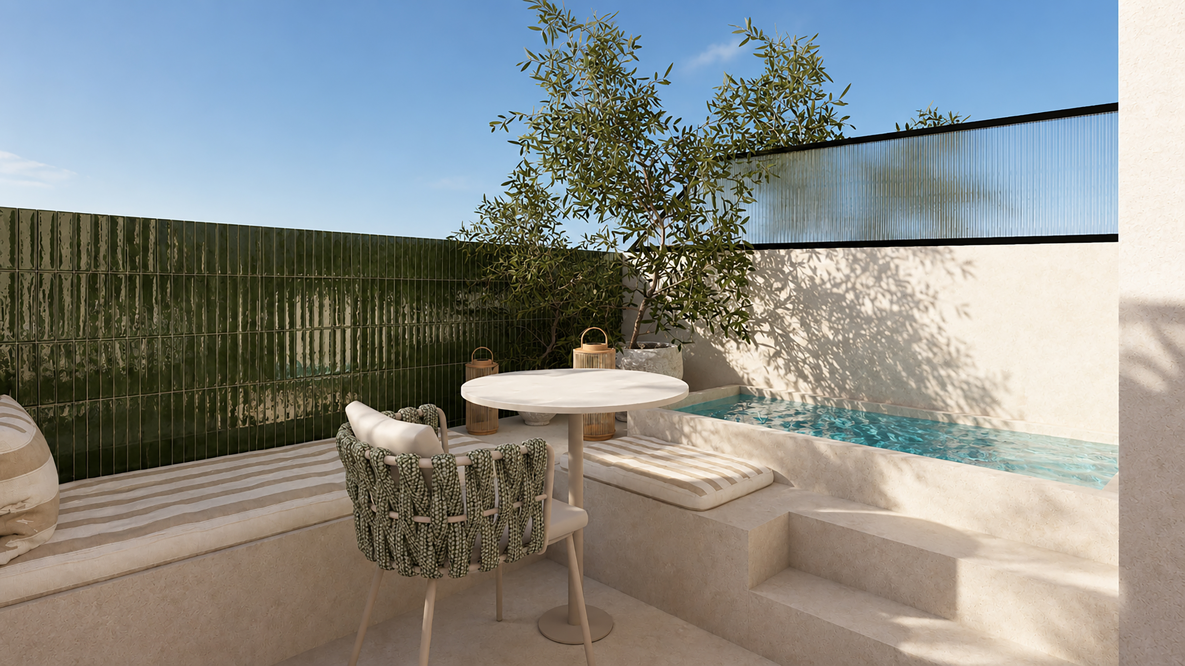 Patio mediterráneo con piscina, azulejos verdes, mesa redonda y olivo.