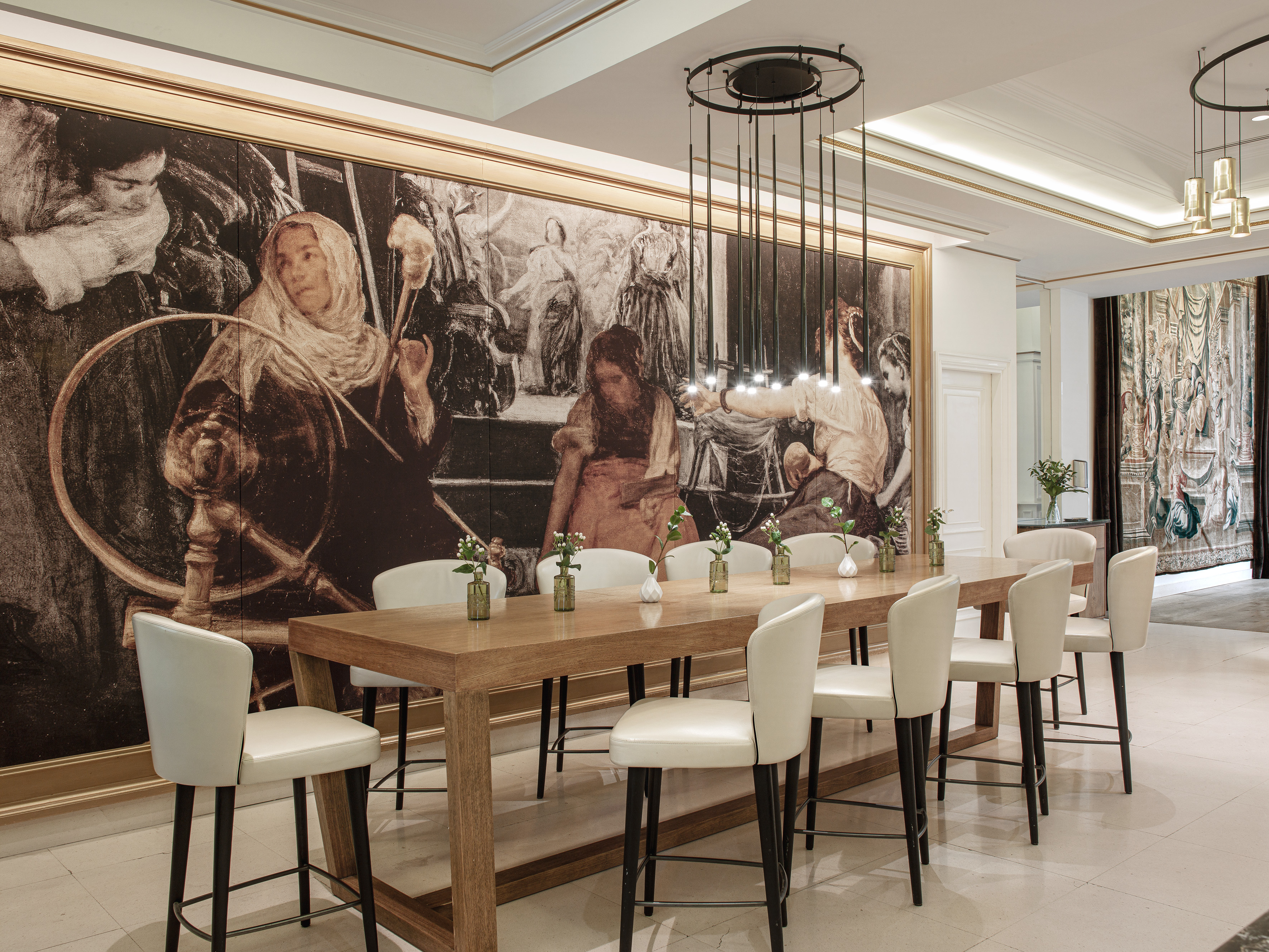 Elegant dining room: wooden table, white chairs, modern lights, wall mural.