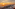 Rooftop terrace with ocean sunset view, outdoor dining tables and beach.