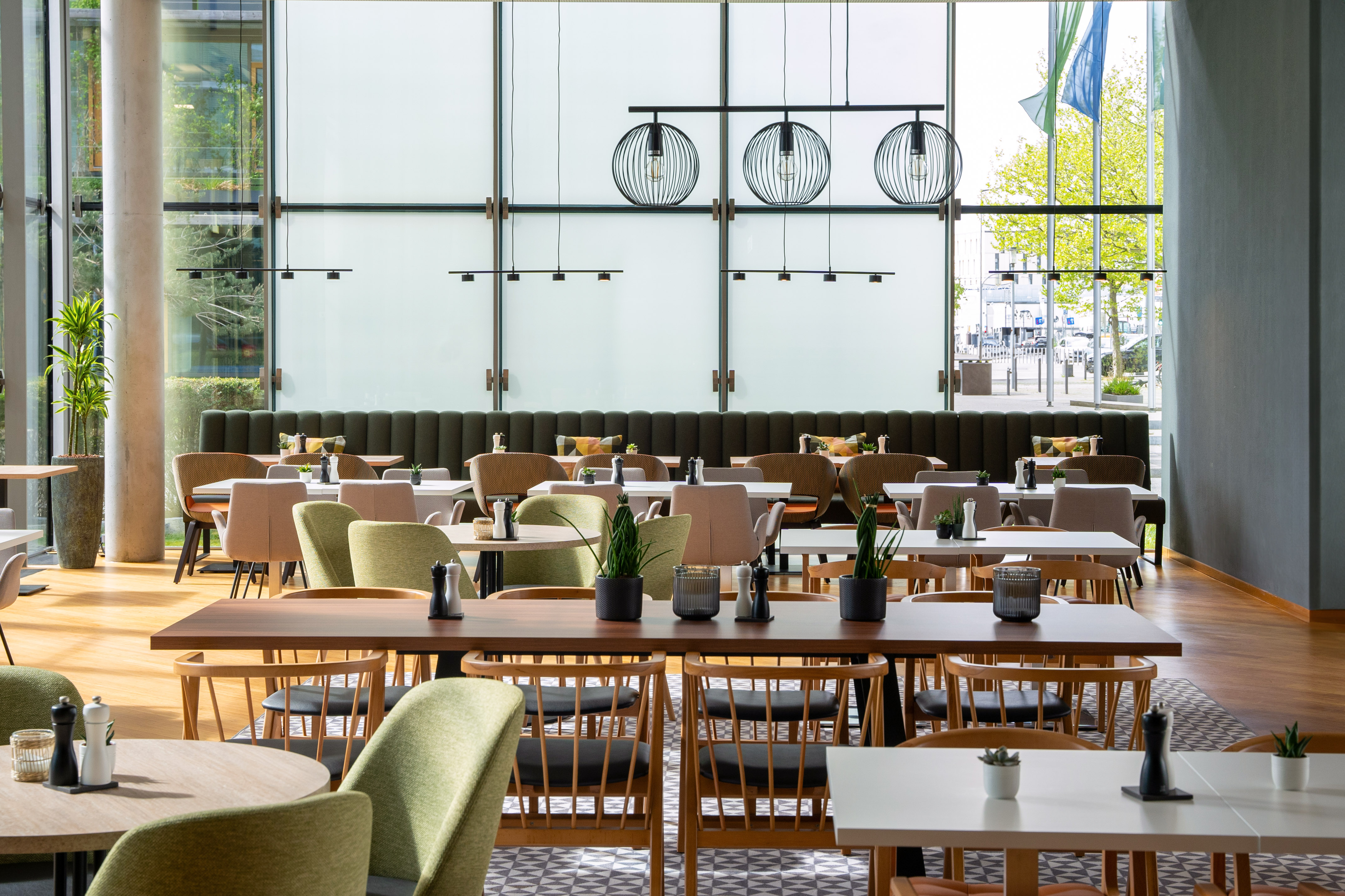Bright modern restaurant dining room with diverse seating and natural light.