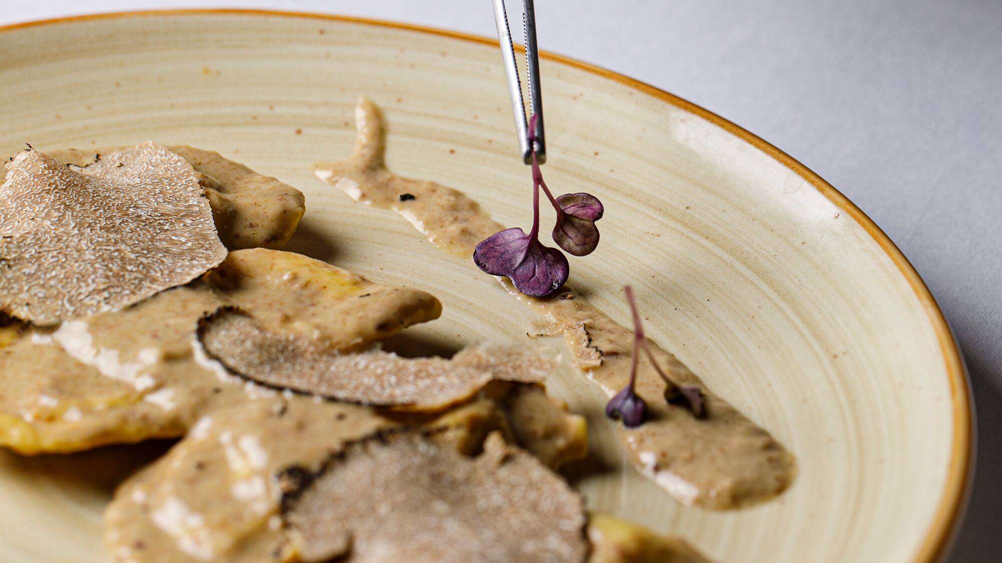 a plate of food with a pair of tweezers