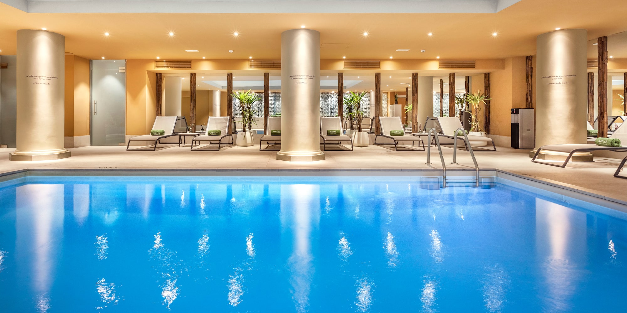 a swimming pool with lounge chairs and a large column