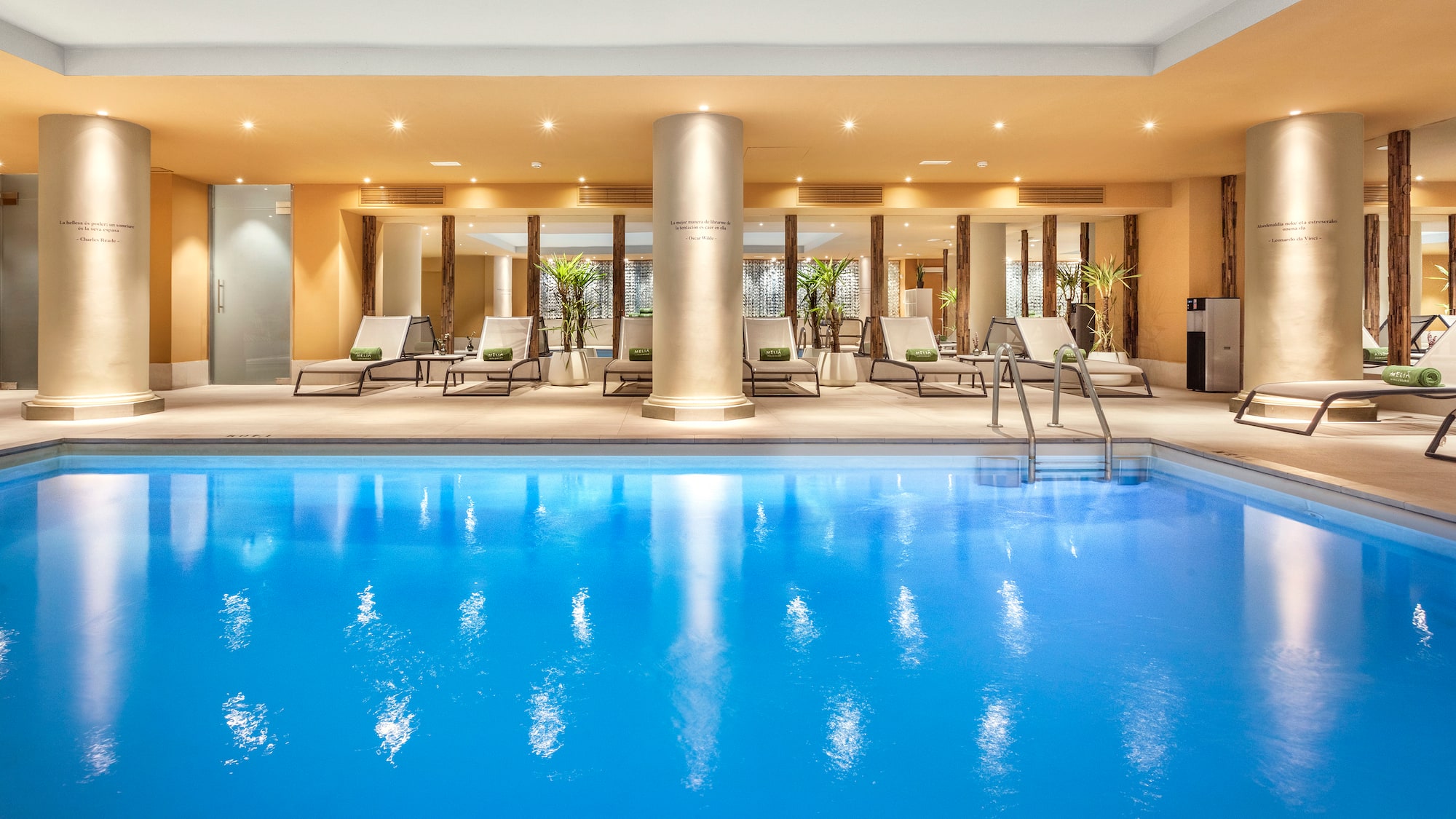 a swimming pool with lounge chairs and a large column