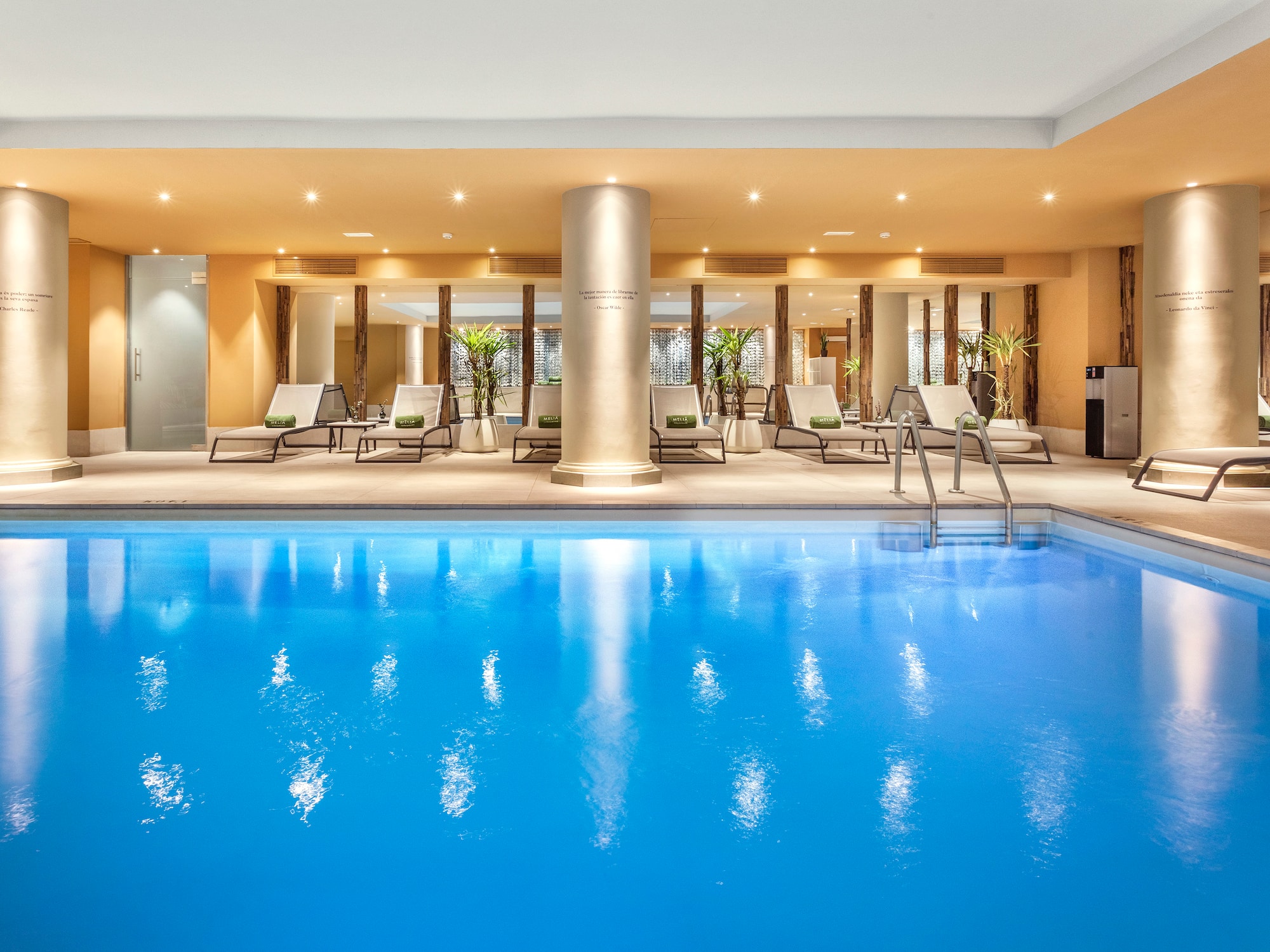 a swimming pool with lounge chairs and a large column