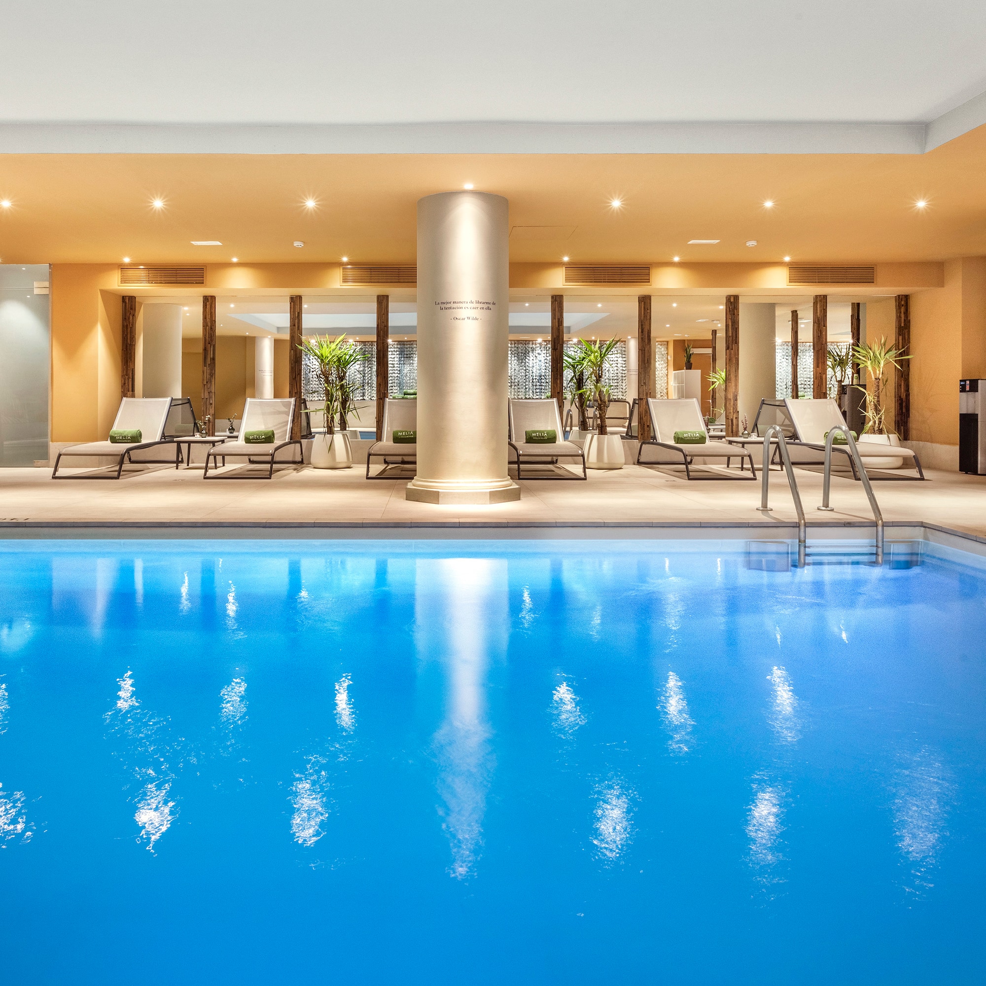 a swimming pool with lounge chairs and a large column