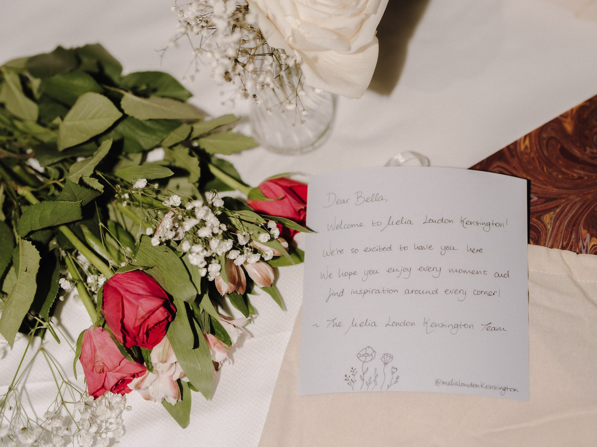 a bouquet of roses and a note on a table