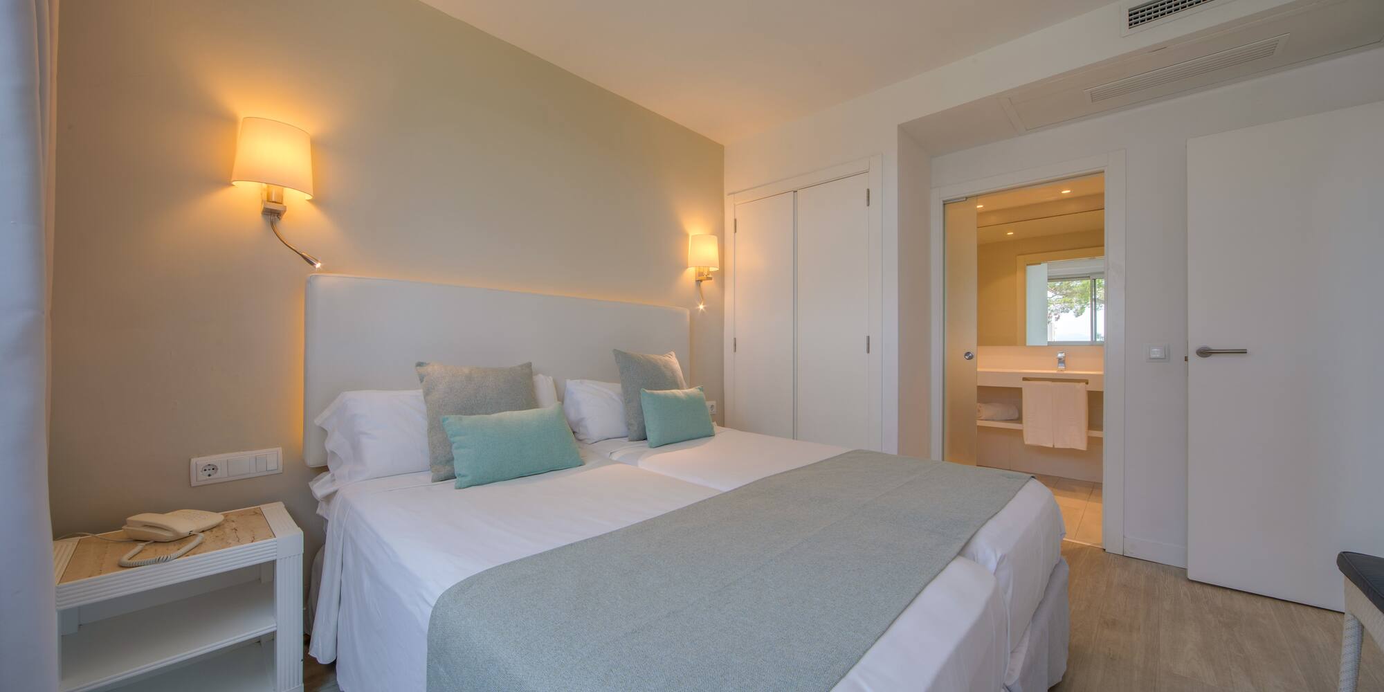 a bed with pillows and a lamp in a room