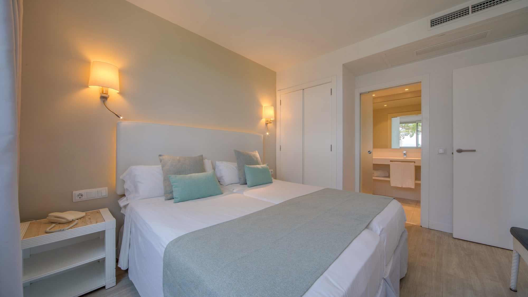 a bed with pillows and a lamp in a room