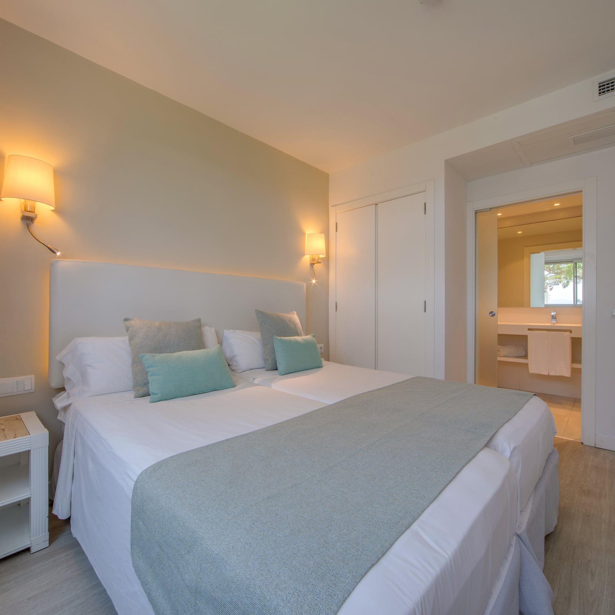 a bed with pillows and a lamp in a room