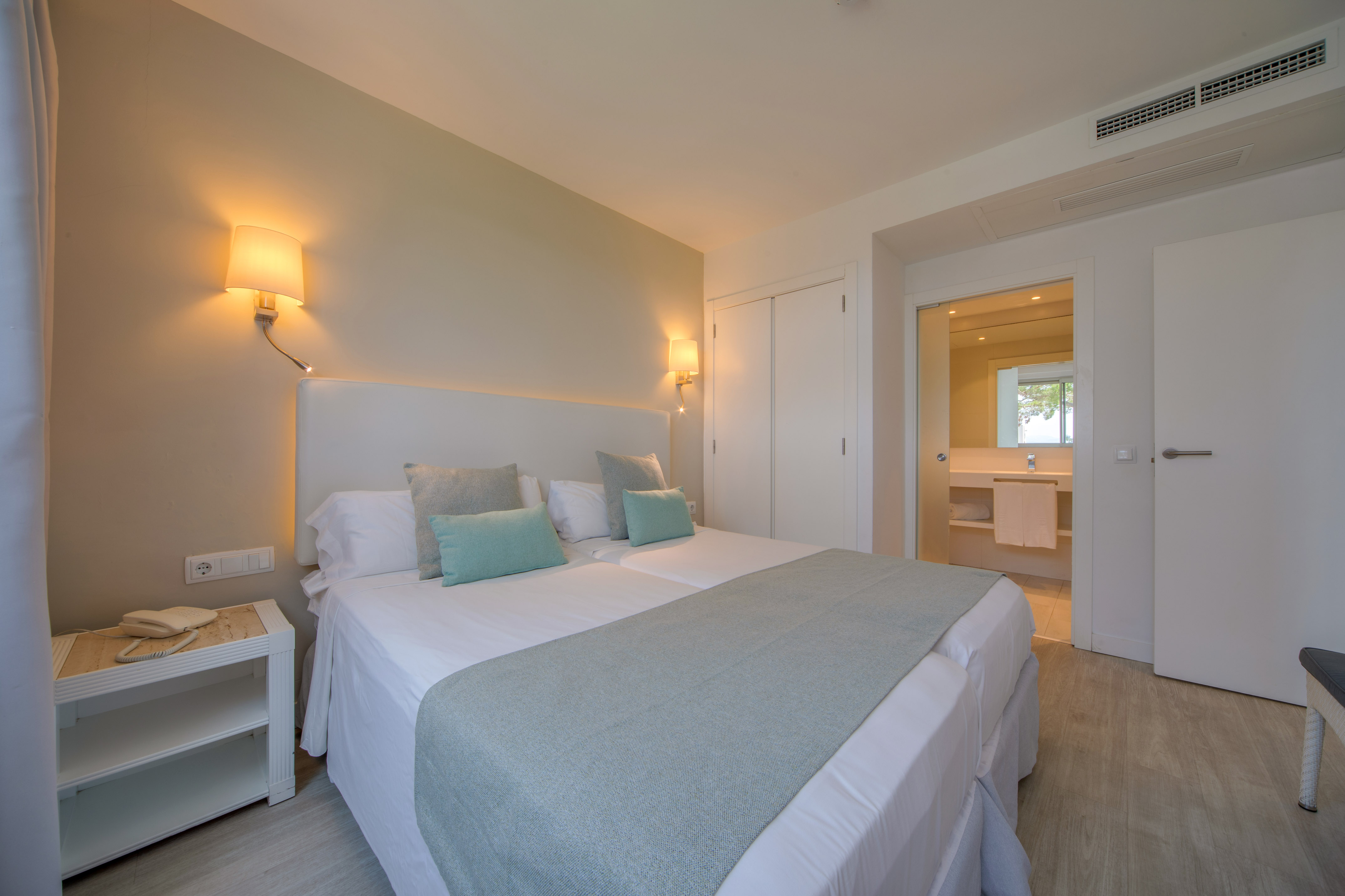 a bed with pillows and a lamp in a room