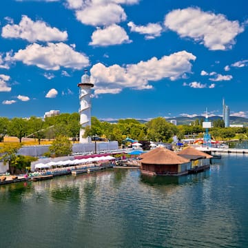 a water with a lighthouse and buildings