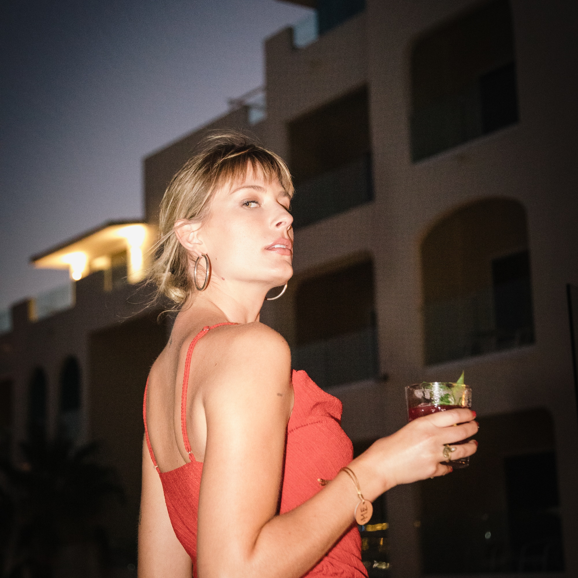 a woman in a red dress holding a drink