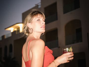 a woman in a red dress holding a drink