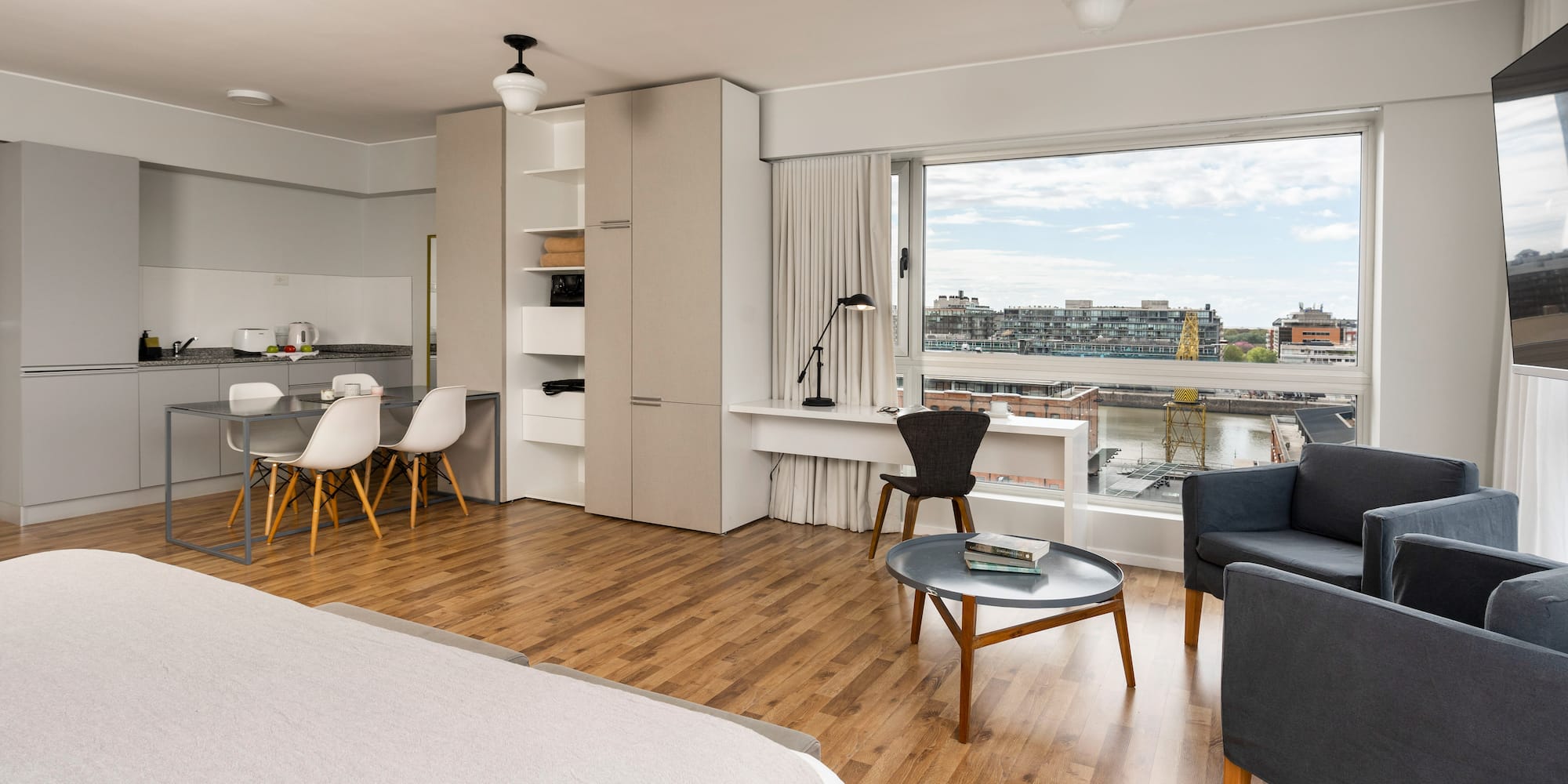 a room with a bed and a table and chairs