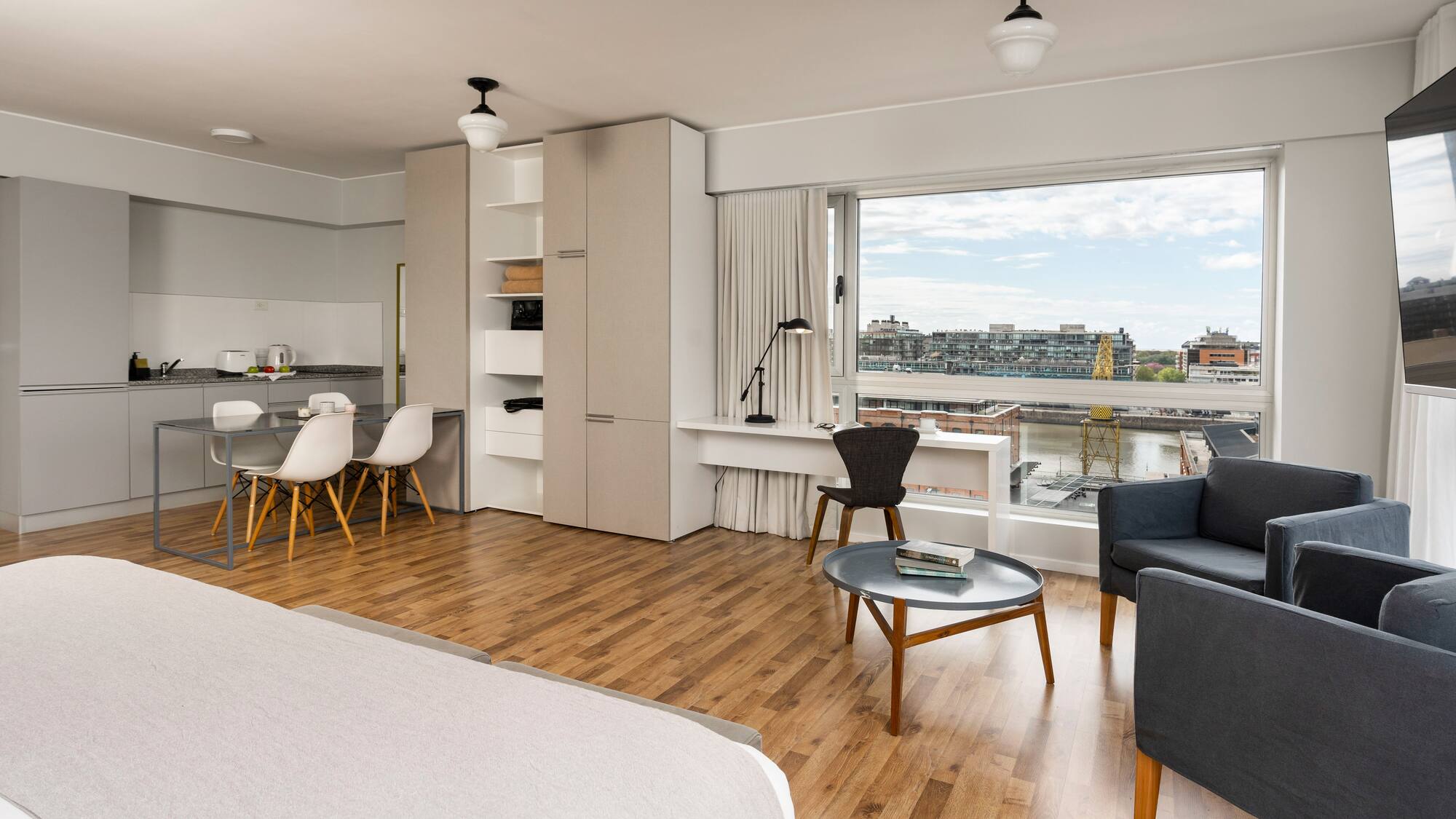 a room with a bed and a table and chairs