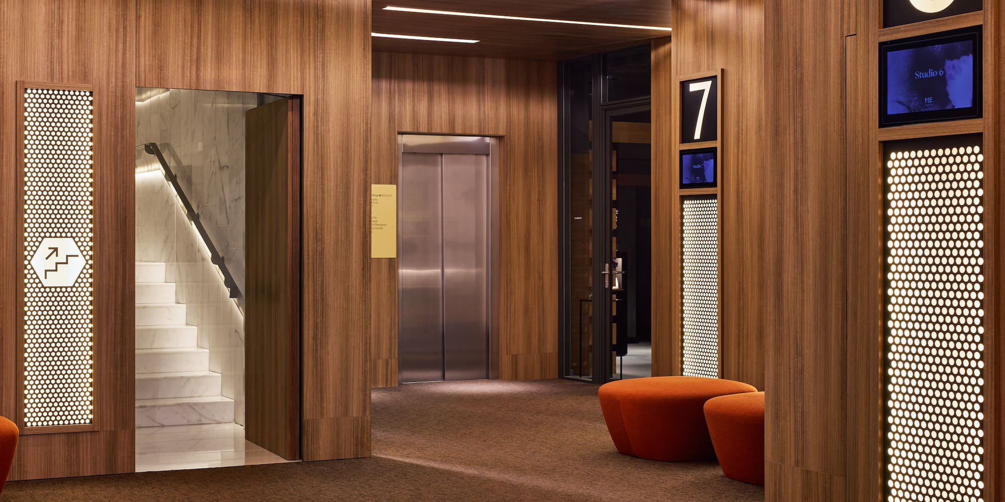 a lobby with a staircase and a chair