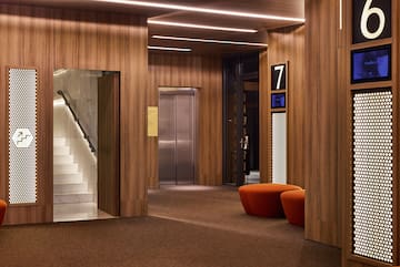 a lobby with a staircase and a chair