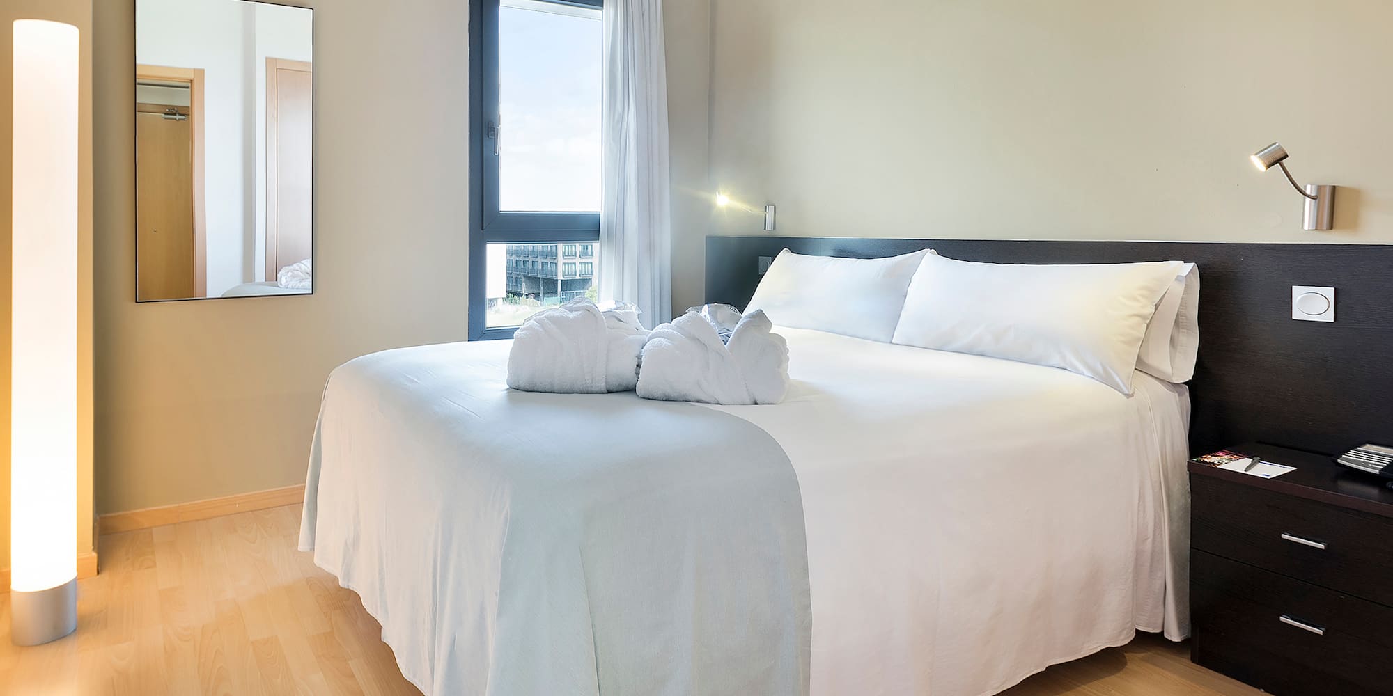 a bed with white sheets and towels