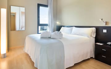 a bed with white sheets and towels